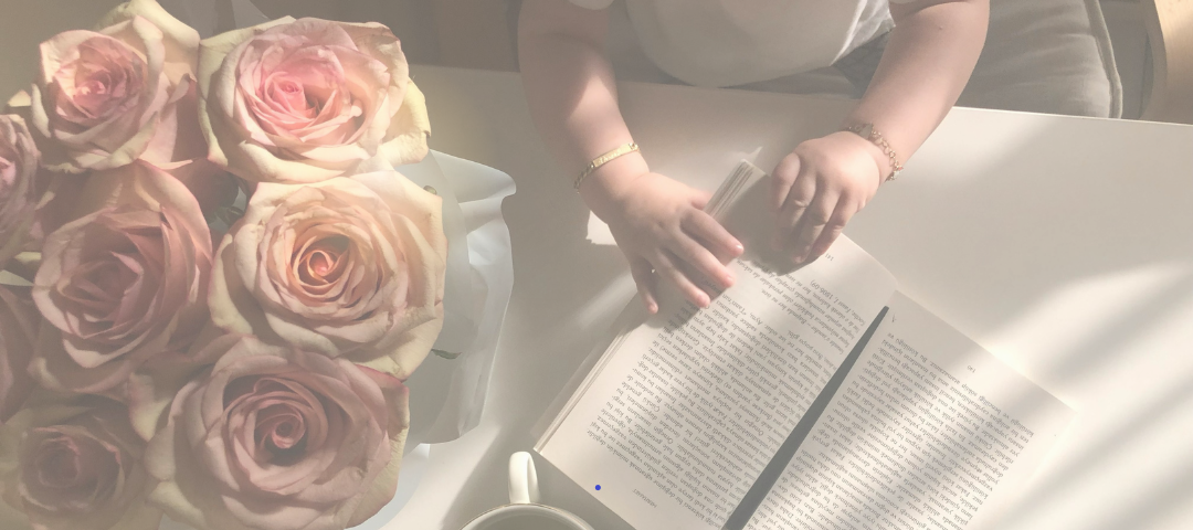 Virág, otthon az íróasztalon, mellette gyerek olvas könyvet